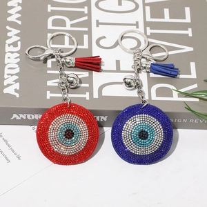 Macro shot of evil eye keychain with sparkling rhinestones, silver bell and tassel charm