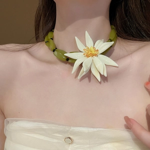 Close-up of a large resin white flower necklace worn on a neck for resort style