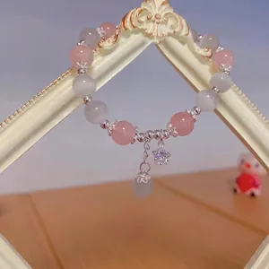 Detail of beaded bracelet with pink quartz, cat eye stones and silver bunny charms