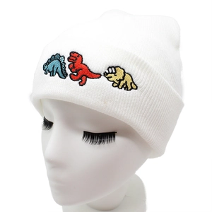 Weiße Strickmütze mit bunten Cartoon-Dinosaurier-Stickereien auf dem Umschlag