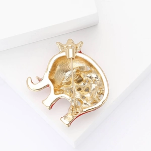Detailed back view of a golden elephant brooch with pin clasp and red enamel accents
