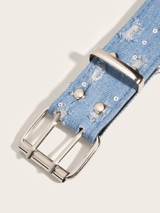 Close-up of punk style denim belt with silver metal buckle and sequin distressed details