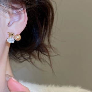 Dettaglio di un orecchino a farfalla placcato oro 18K con zircone e perla su orecchio