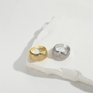 Luxe gold and silver open rings with zircon stones displayed on white decorative stones
