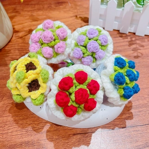 Handmade crochet flower keychains in five colors on a rustic wooden surface with white base