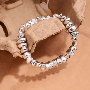 Minimalist silver irregular bead bracelet with organic crushed silver beads on brown paper