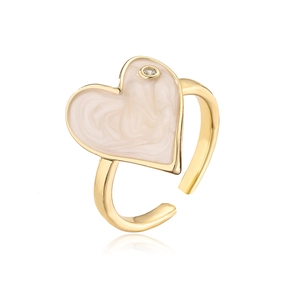 Detailed close-up of 18K gold heart ring with cream enamel and sparkling zircon stone