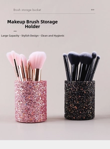 Detail of pink and black glitter makeup brush holders with rose gold metal accents