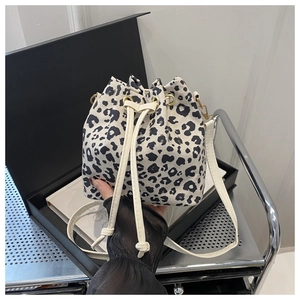 Détail du sac seau imprimé léopard avec cordon de serrage blanc et fine bandoulière