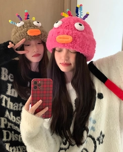 Detail of funny plush knitted hat featuring cute 3D eyes and orange duck beak details