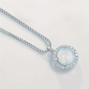 Macro shot of silver box chain necklace with 8mm round white opal pendant and zircon halo
