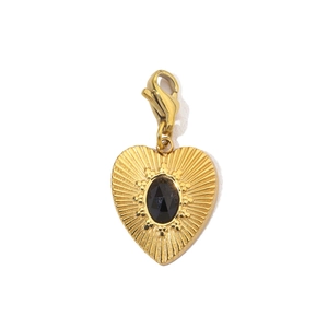 Detail showing a golden heart pendant with a faceted black gemstone and radial relief texture