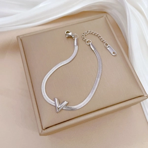 Macro shot of silver V-shaped pendant on stainless steel chain with S.STEEL hallmark