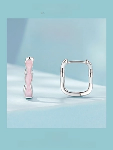Detail view of pink square 925 sterling silver ear buckles with wavy line design