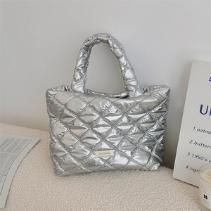 Detail of silver quilted tote bag with metallic finish and soft padded handles
