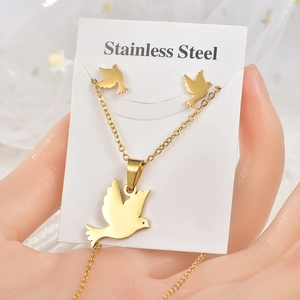 Detail view of a gold stainless steel peace dove necklace and earrings jewelry set