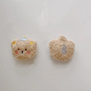 Detail view of plush bear charm with embroidery and back fabric opening for DIY