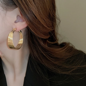 Close-up of gold layered hoop earrings on model featuring minimalist geometric design
