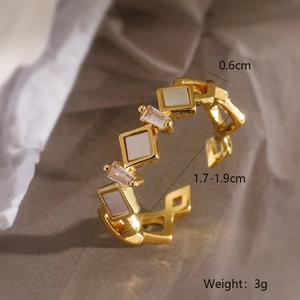 Close-up of geometric 18K gold plated ring with white shell and baguette crystal detail