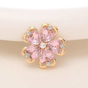 Detailansicht der goldfarbenen Blume mit rosa Herzkristallen und glänzenden Steinen