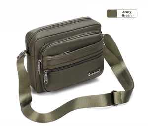 Detail view of army green nylon crossbody bag with multi-layer zipper compartments