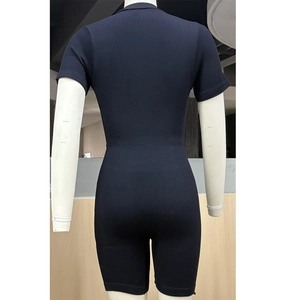Rear view of black short sleeve ribbed seamless yoga jumpsuit on a female mannequin