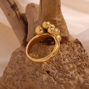 Macro shot of 18K gold-plated stainless steel balloon bubble ring on natural wood