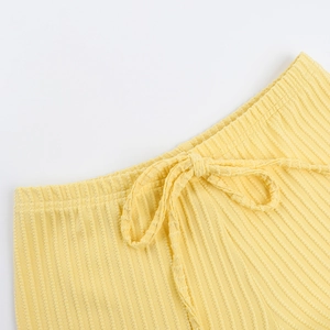 Detail of yellow ribbed knit texture and elastic waistband with flat drawstring cords