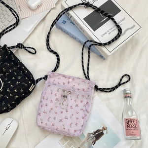 Detail of floral canvas crossbody bags showing fabric texture and braided straps