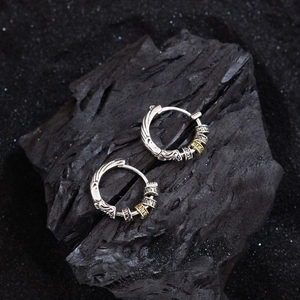 Retro mixed metal hoop earrings with relief patterns on textured black stone