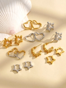 Collection of star and heart-shaped stainless steel earrings with pearls on white shell