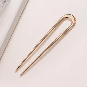 Elegant gold U-shaped metal hair pin with wavy textured top for sleek updo styling