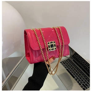 Close-up of rose red quilted leather bag with gold chain and black jewel encrusted lock