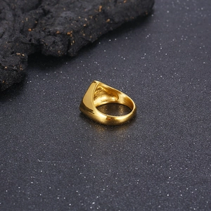 Macro shot of a golden polished geometric signet ring on a dark textured rock background