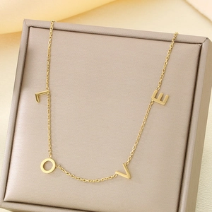 Macro view of gold-plated chain with LOVE letter charms in a jewelry gift box