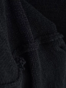 Gros plan macro d'un tissu en maille noire montrant la texture et les motifs tissés complexes