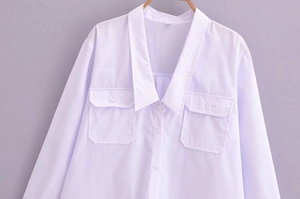 Close-up of white deep V-neck shirt with pointed collar and buttoned chest pockets