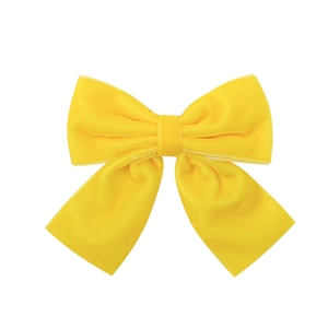 Detail shot of bright yellow velvet handmade bow hair clip with premium smooth texture