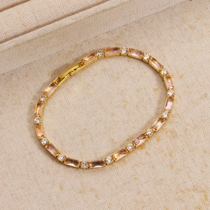 Dettaglio di un bracciale tennis dorato con zirconi champagne a taglio baguette