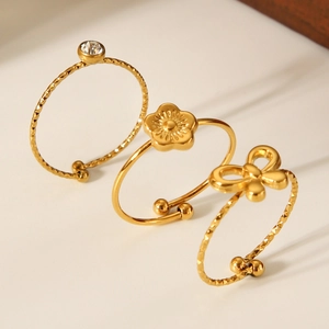 Close-up of 18K gold plated bow and flower rings with cubic zirconia crystal details