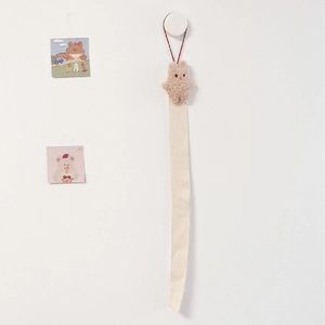 Detail of wall-hanging organizer belt with a plush brown bear for children's hair accessories