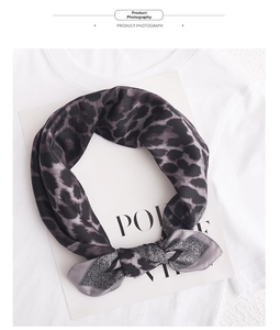 Close-up of leopard print satin square scarf with silky texture and smooth gray leopard pattern