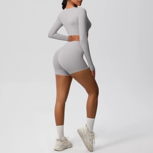 Rear view of a tight light grey yoga set featuring long sleeves and high-waist shorts