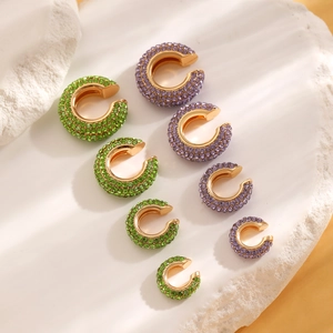 Detailed view of luxury green and purple rhinestone ear clips in five graduated sizes