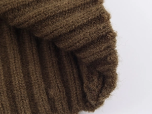 Gros plan sur la maille côtelée marron foncé montrant la texture douce du tissu tricoté
