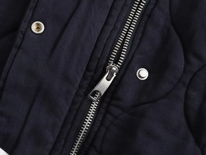Détail macro de la fermeture éclair en métal et des boutons sur la veste bomber marine