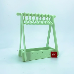 Detail view of mint green acrylic jewelry rack with mini clothes hangers for earrings