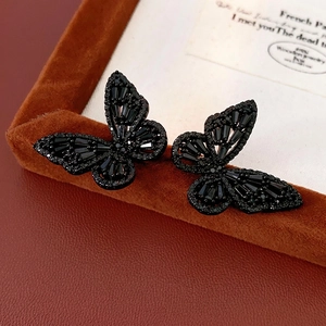 Elegant black hollow butterfly earrings with micro-set crystals on velvet jewelry box