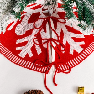 Gestrickte Weihnachtsbaumdecke mit weißem Schneeflockenmuster und rotem Verschluss