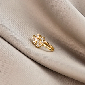 Macro view of gold puzzle-shaped non-piercing clip with micro-set cubic zirconia